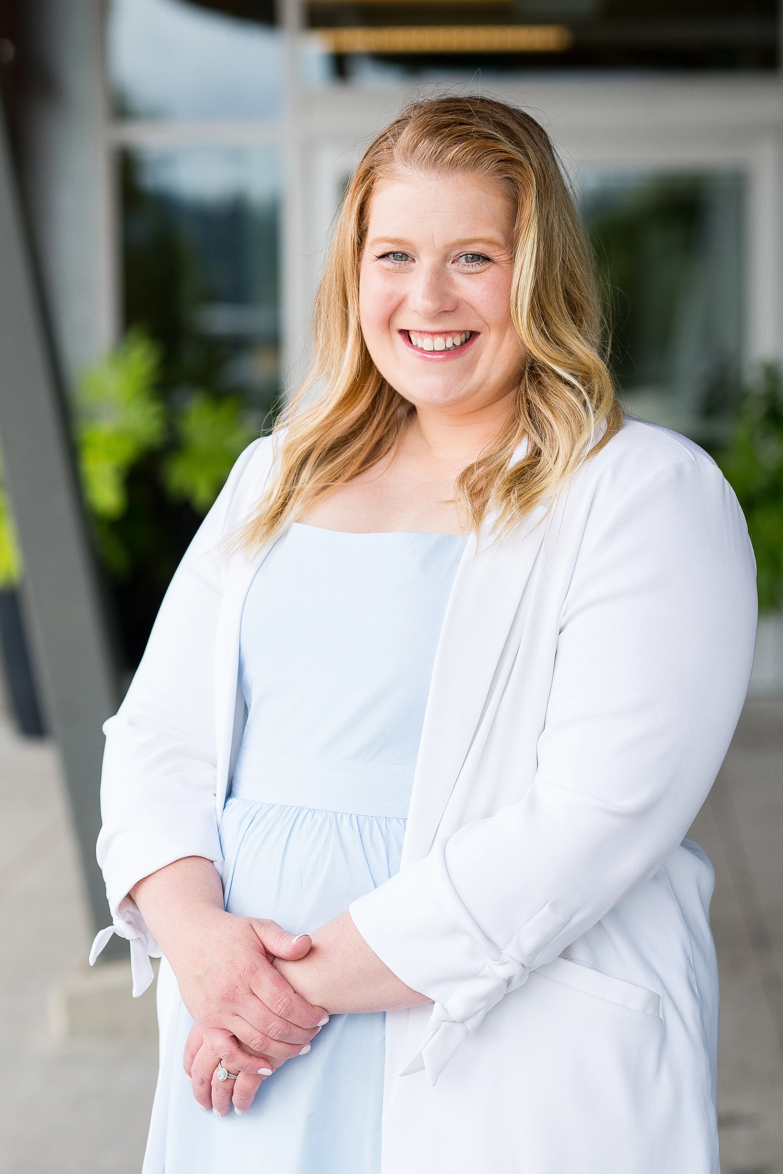 Jessica Morrison smiling, hands clasped, outdoors.
